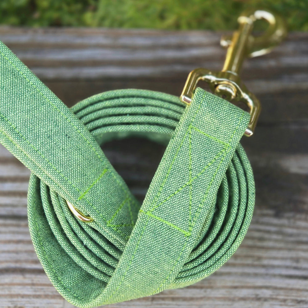 a bright spring green cotton linen dog leash with gold clip on a wooden surface