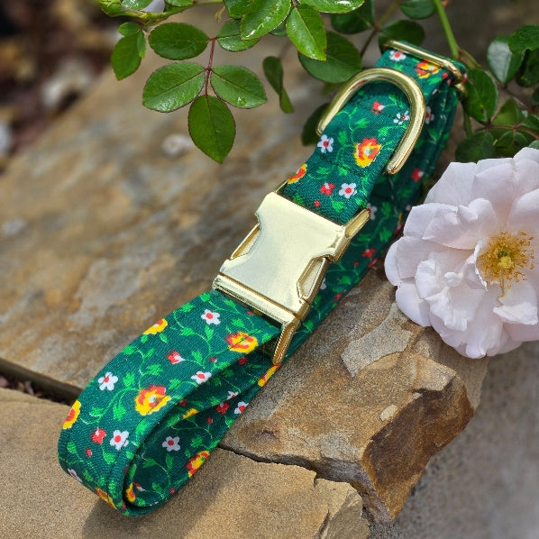 Dainty flowers in red-orange, yellow, and white, leaves are lime green and more vine-like. fabric is cotton and estimated to be from the 1960's. background is Kelly green. shown with shiny gold metal hardware.