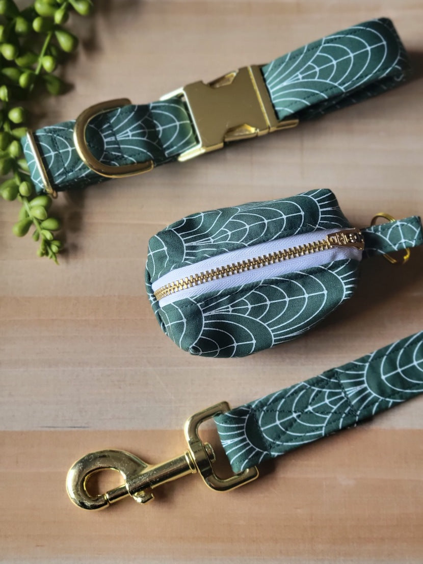 art deco style, white fan lines on dark green background, dog set including collar, leash, and waste bag