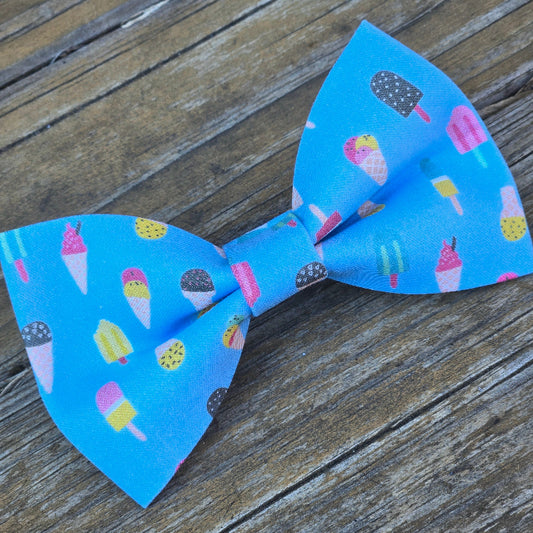 Blue bow tie with ice cream and popsicle pattern on a wooden surface