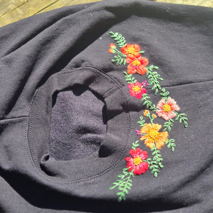 Black sweatshirts and embroidery in shades of orange, coral and pink, bright embroidery along the collar.
