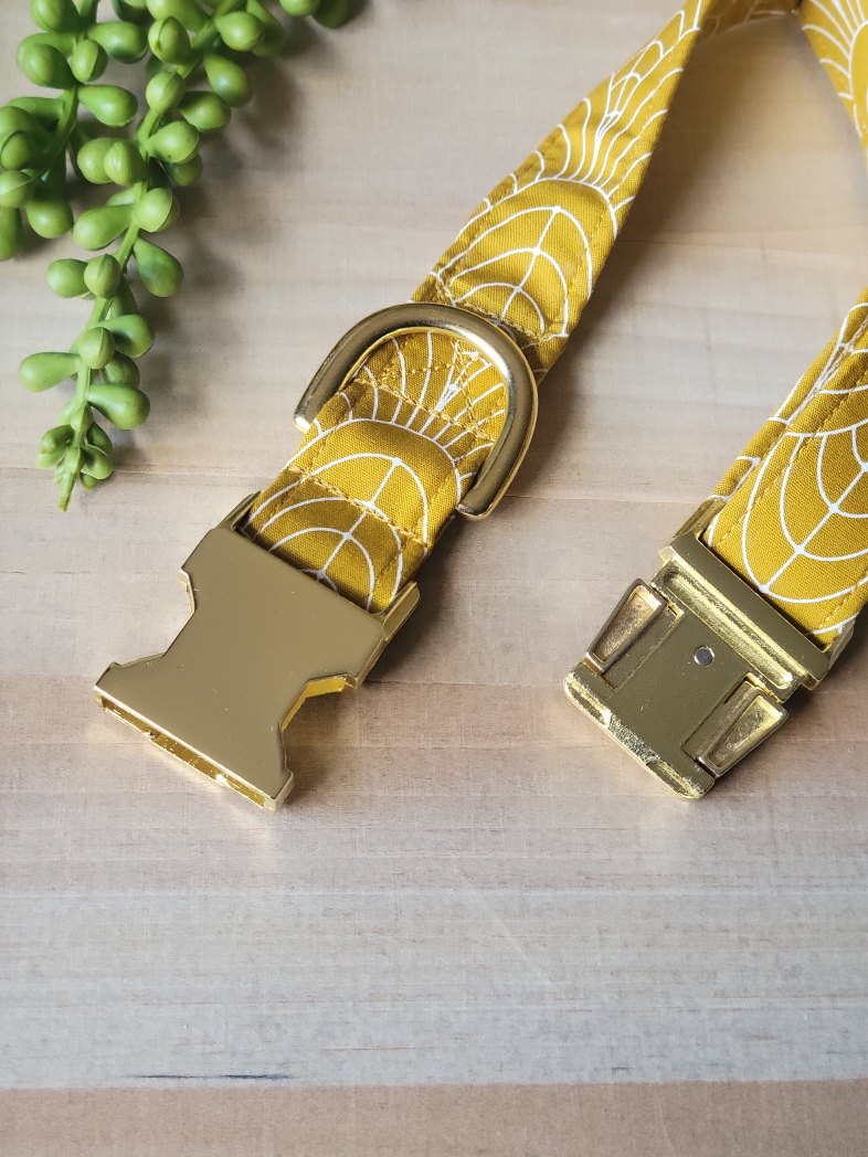 art deco dog collar with white curved lines on mustard yellow background, gold hardware