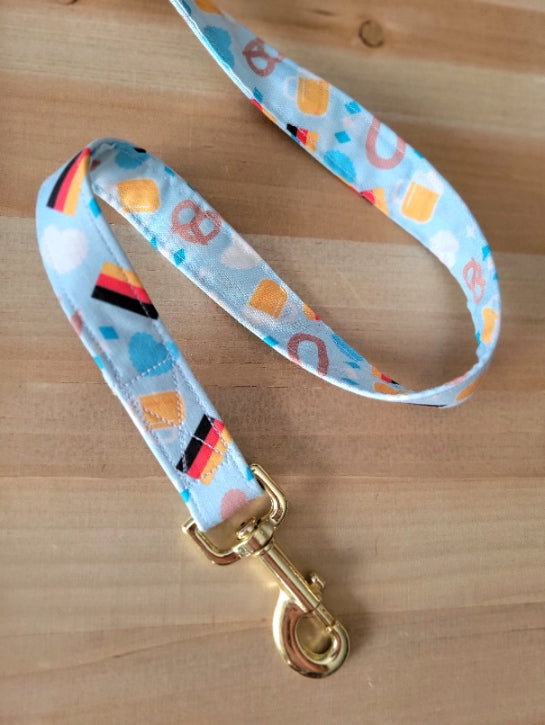 oktoberfest dog leash with pretzels, beer, sausages, hearts and german flags on a light blue background