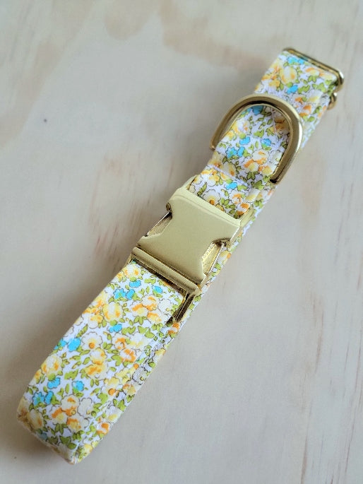 yellow and blue small florals with lime green leaves in a vintage type appearance, white background, shown with gold metal buckle