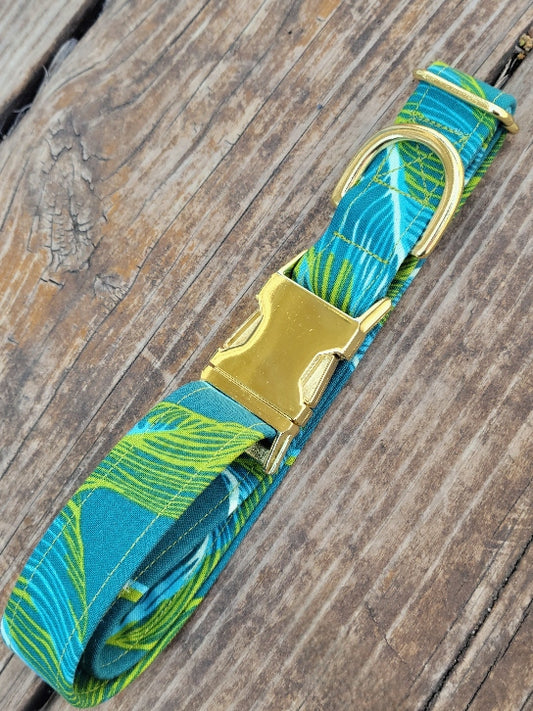 tropical Leaves in bright pops of lime green, and bright blue on a teal background. pattern is large and with lines for a more abstract design. shown with gold buckle.