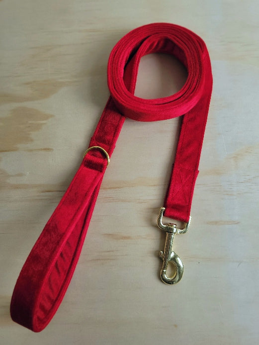 bright holiday red velvet dog leash shown as 1" wide with shiny gold metal hardware. velvet is luxurious, soft, and with a lovely sheen